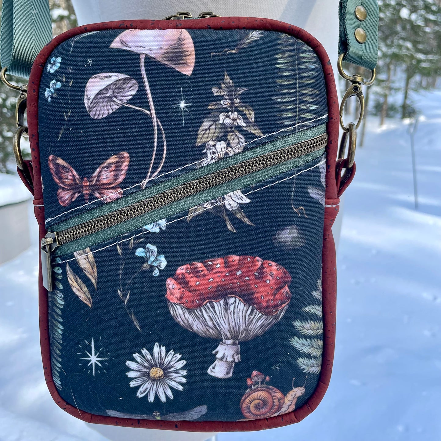 Sac bandoulière en liège bourgogne au devant en canevas à motif de fleurs et de champignons.