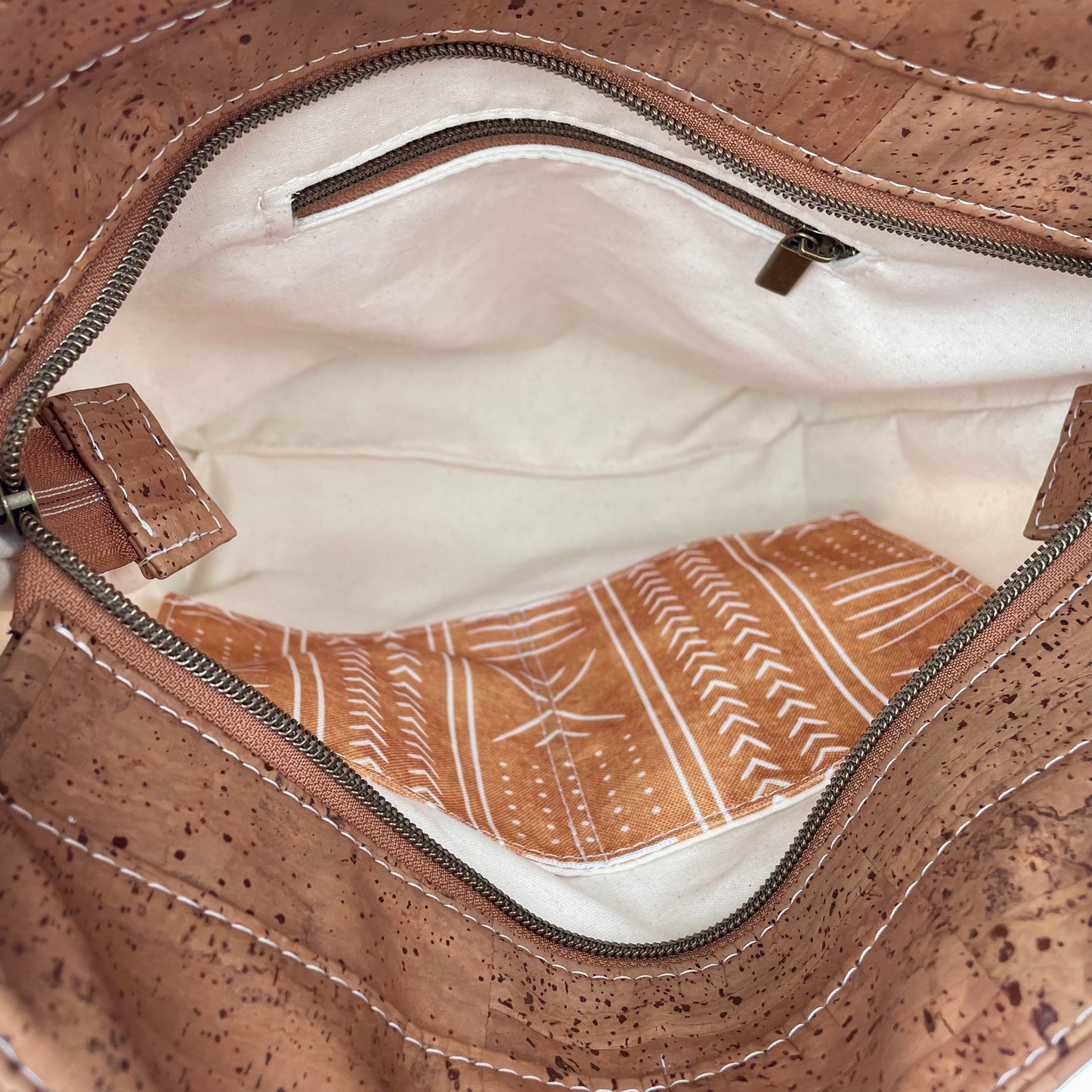 Sac en bandoulière orangé à motifs lignés blancs, liège brun pâle.