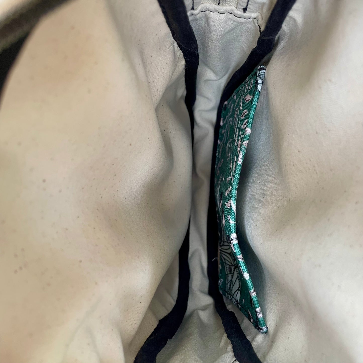 Sac bandoulière en liège noir au devant en canevas vert à motif de papillons noirs et beiges