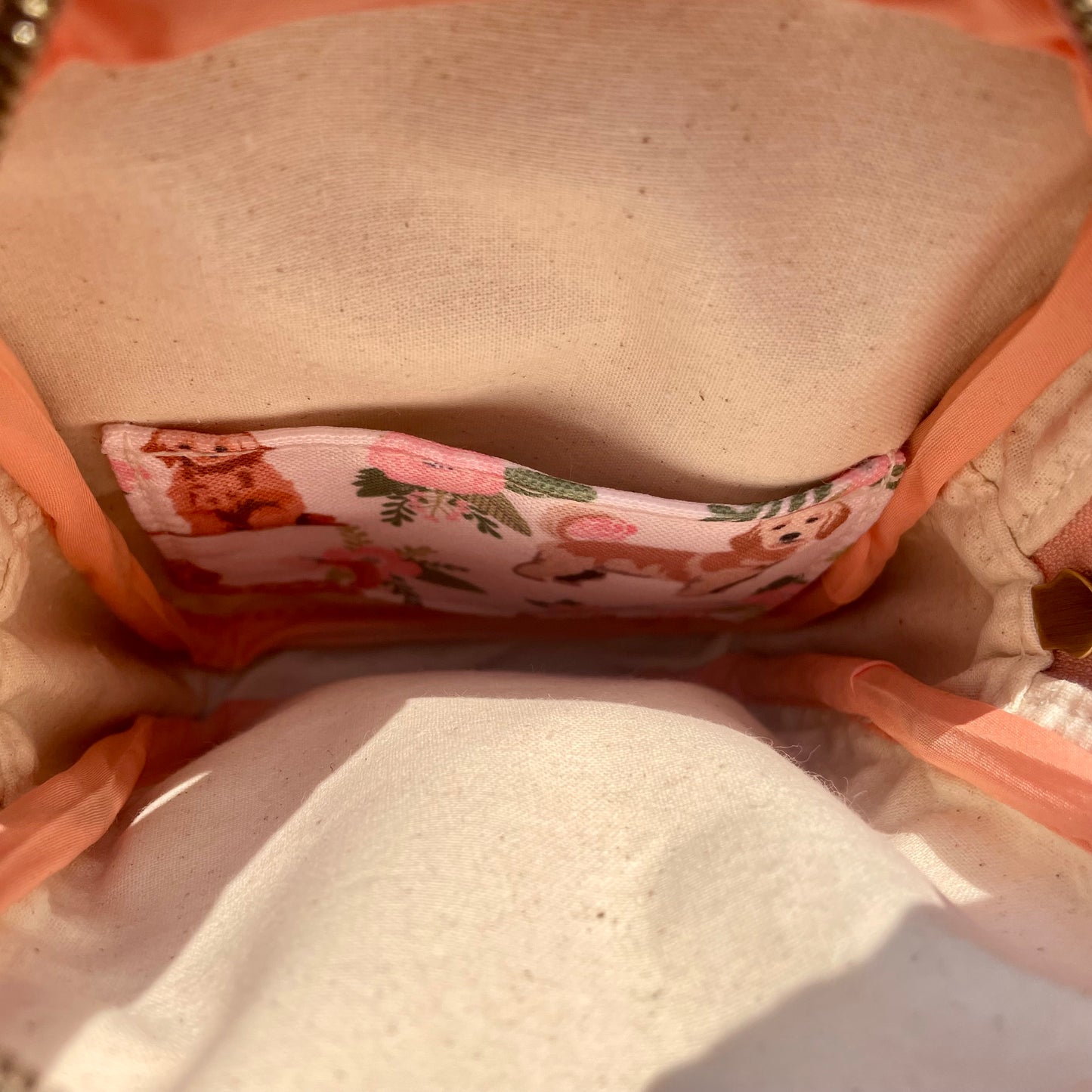 Sac de corps en liège brun pâle au devant en canevas rose à motifs de chiens.