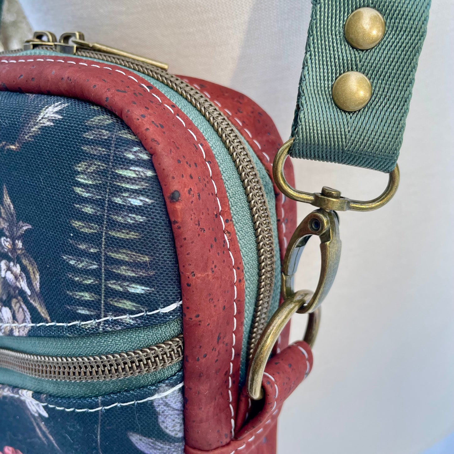 Sac bandoulière en liège bourgogne au devant en canevas à motif de fleurs et de champignons.