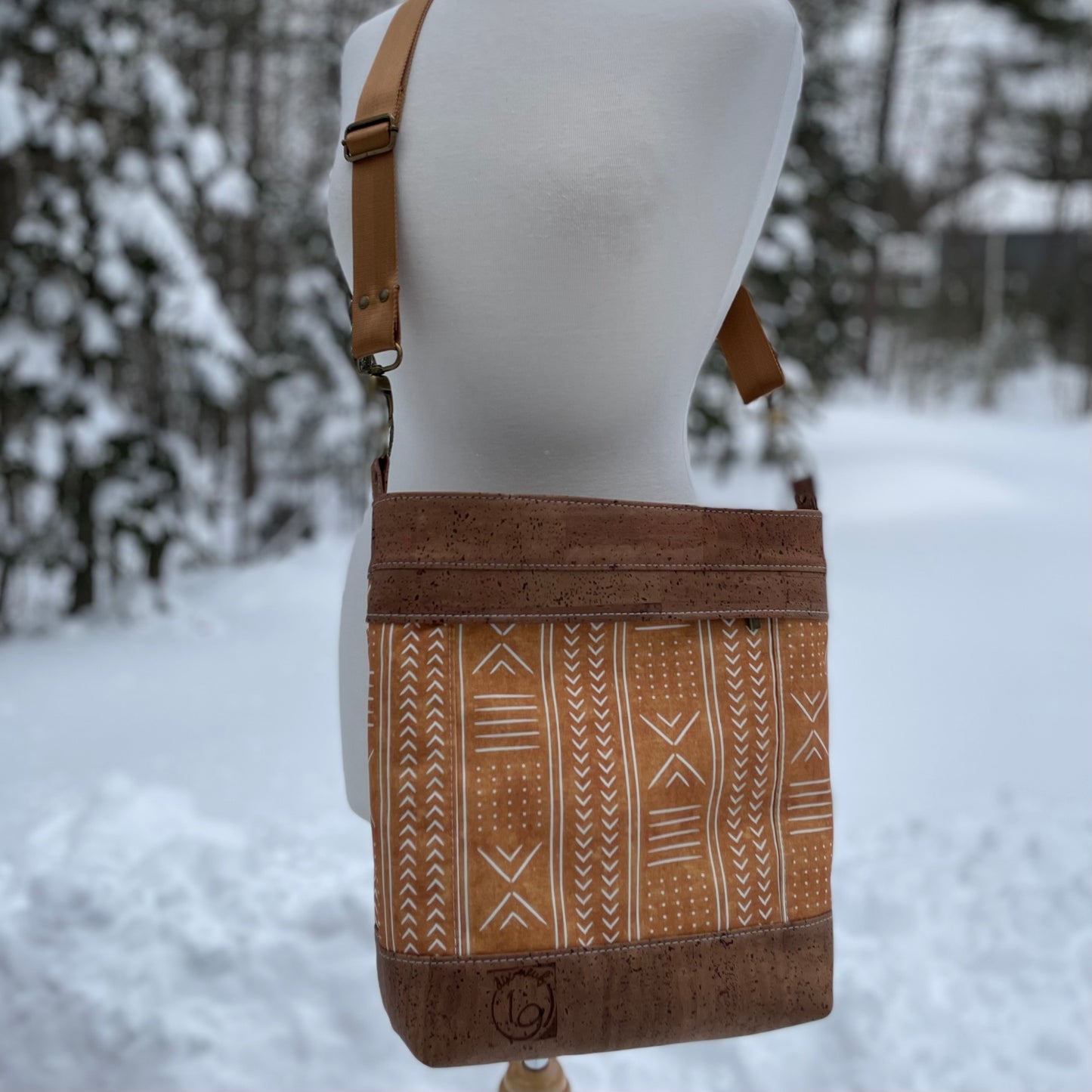 Sac en bandoulière orangé à motifs lignés blancs, liège brun pâle.