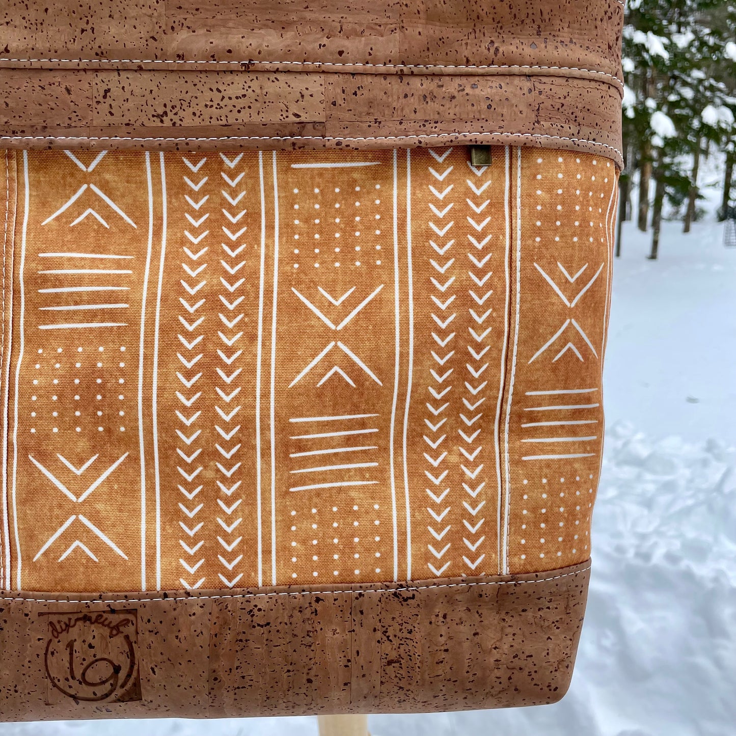 Sac en bandoulière orangé à motifs lignés blancs, liège brun pâle.