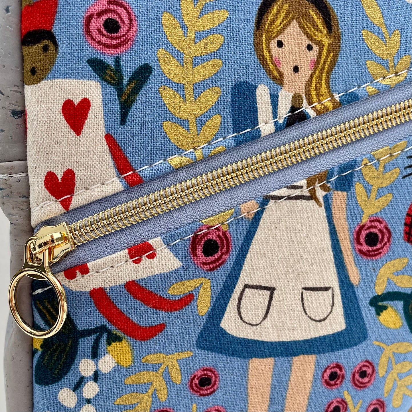 Sac bandoulière en liège gris pâle au devant en canevas coloré à motif inspirés de Alice.