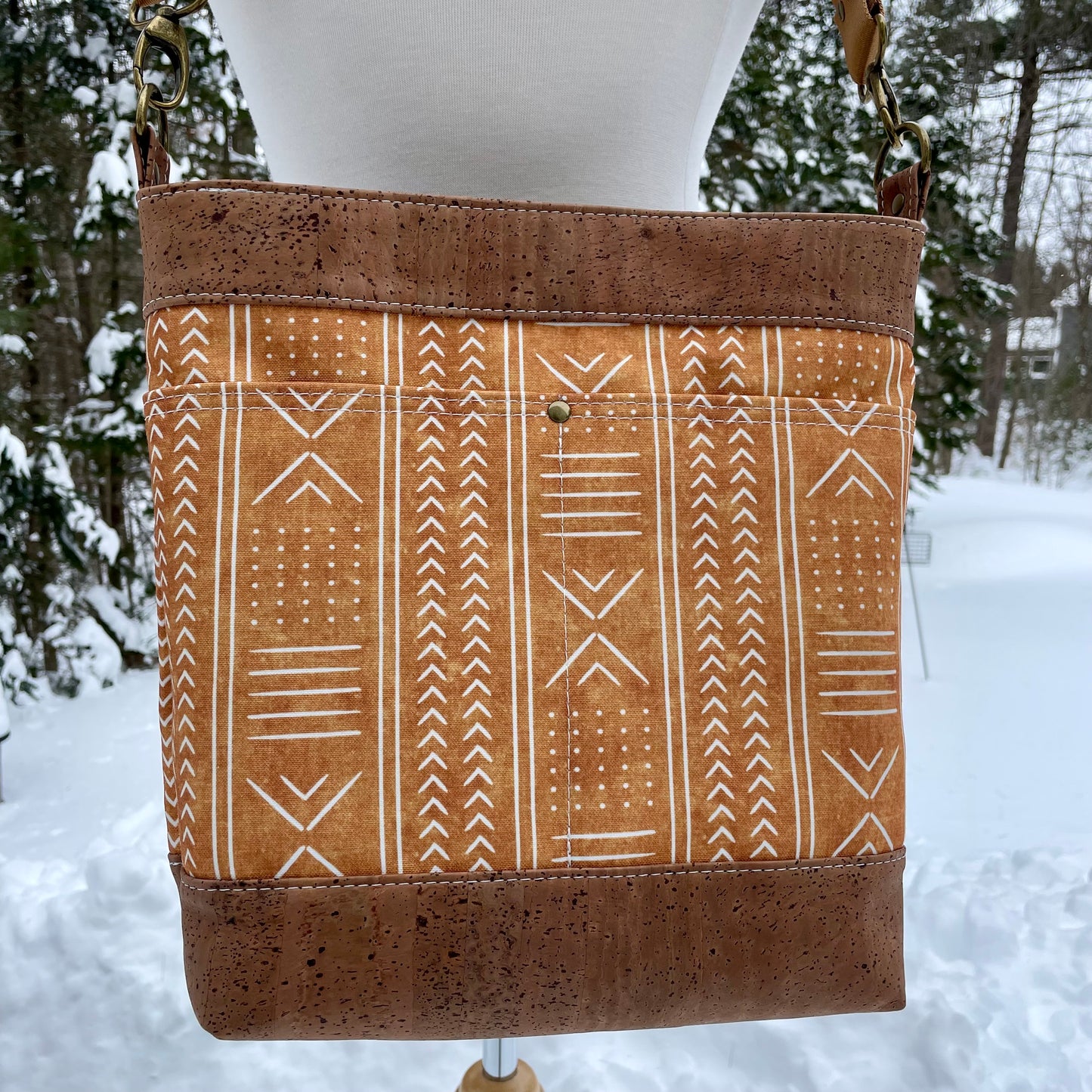 Sac en bandoulière orangé à motifs lignés blancs, liège brun pâle.