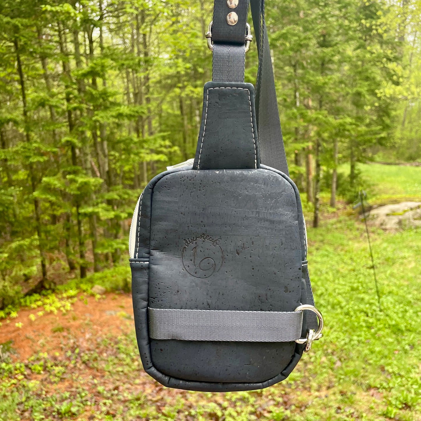 Sac de corps en liège bleu marin au devant en canevas à motifs de fleurs.