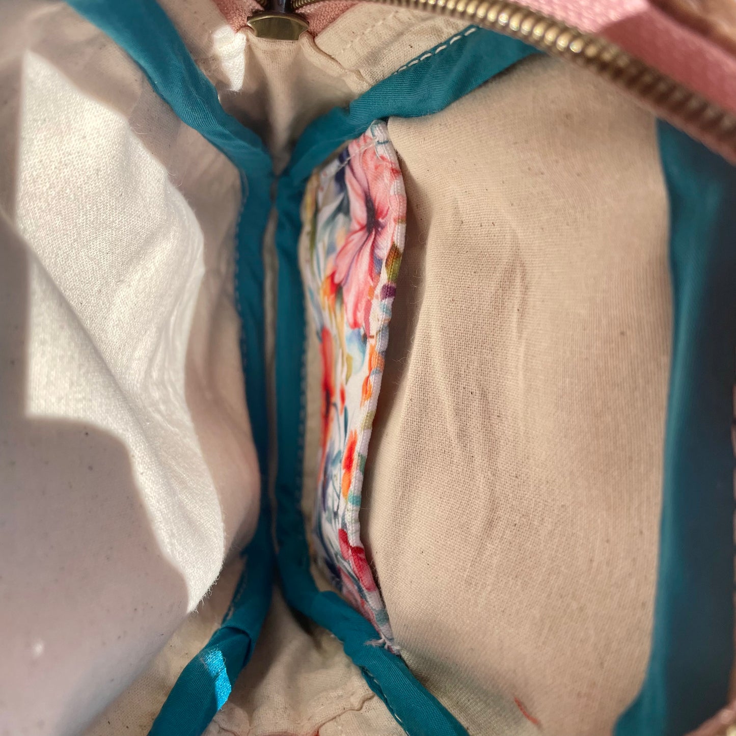 Sac de corps en liège brun pâle au devant en canevas à motifs de fleurs colorées.