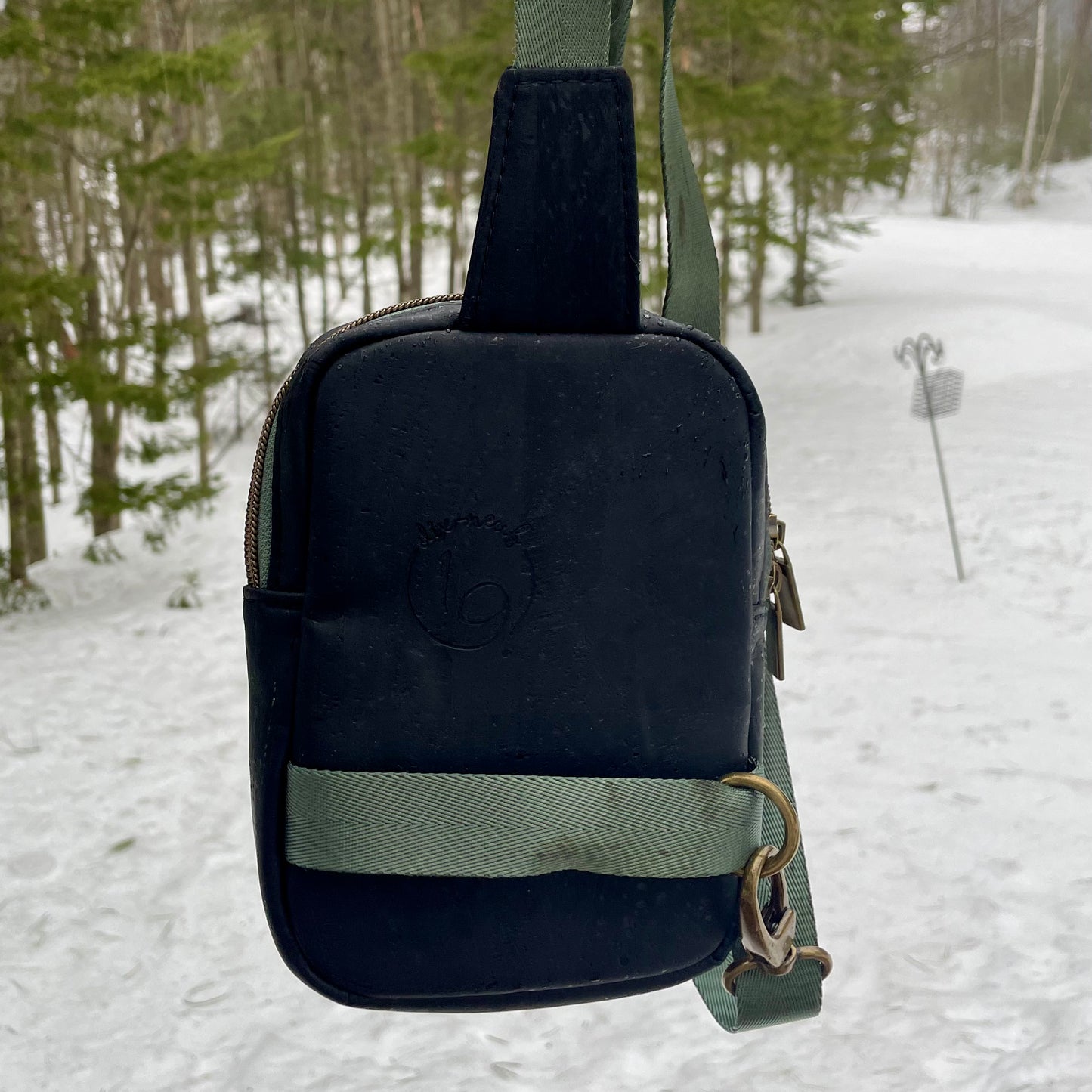 Sac de corps en liège noir au devant en canevas à motifs de fleurs.