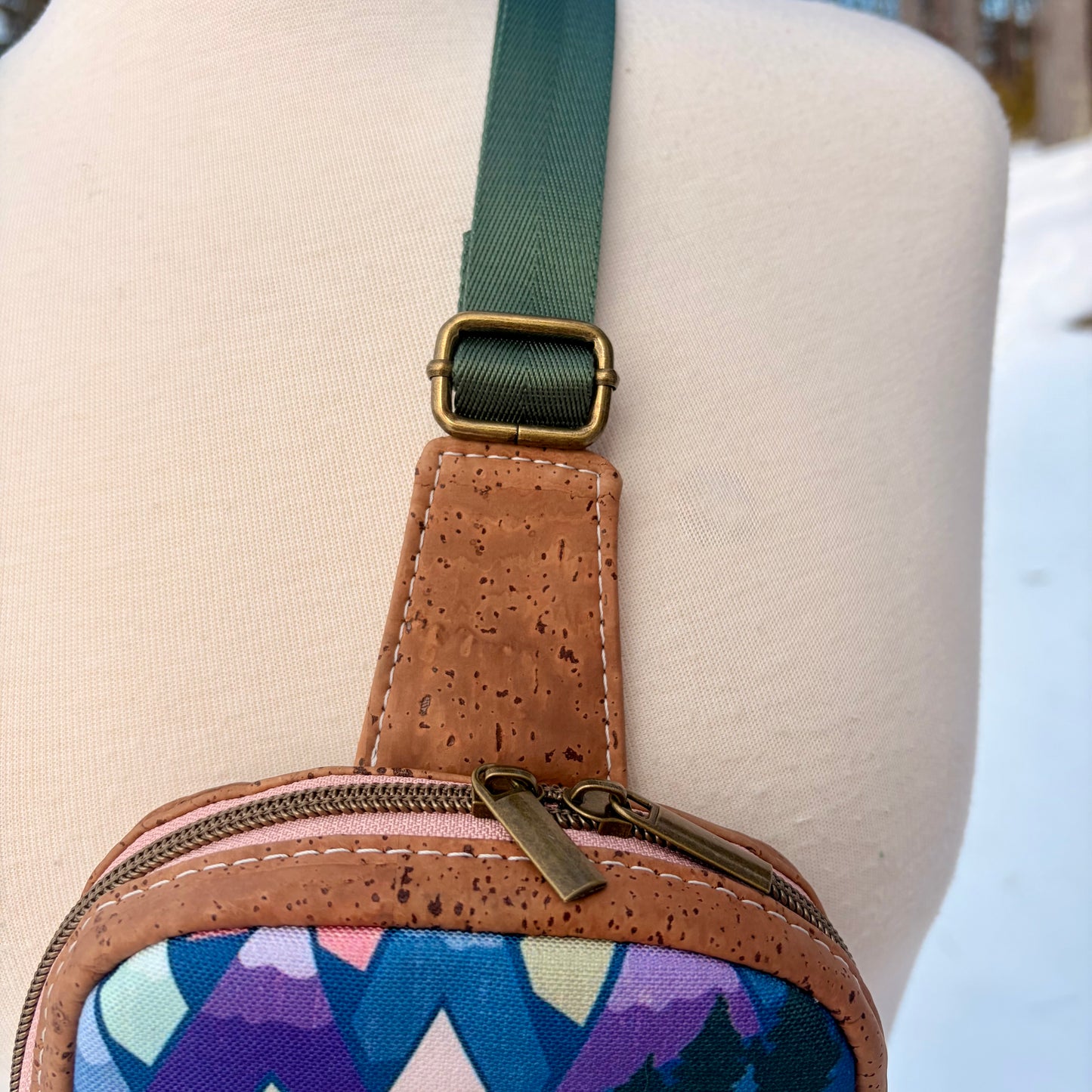 Sac de corps en liège brun pâle au devant en canevas à motif de montagnes colorées.