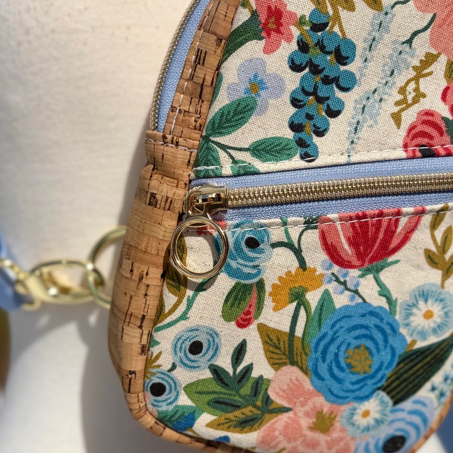 Sac de corps en liège naturel au devant en canevas à motif de fleurs colorées.