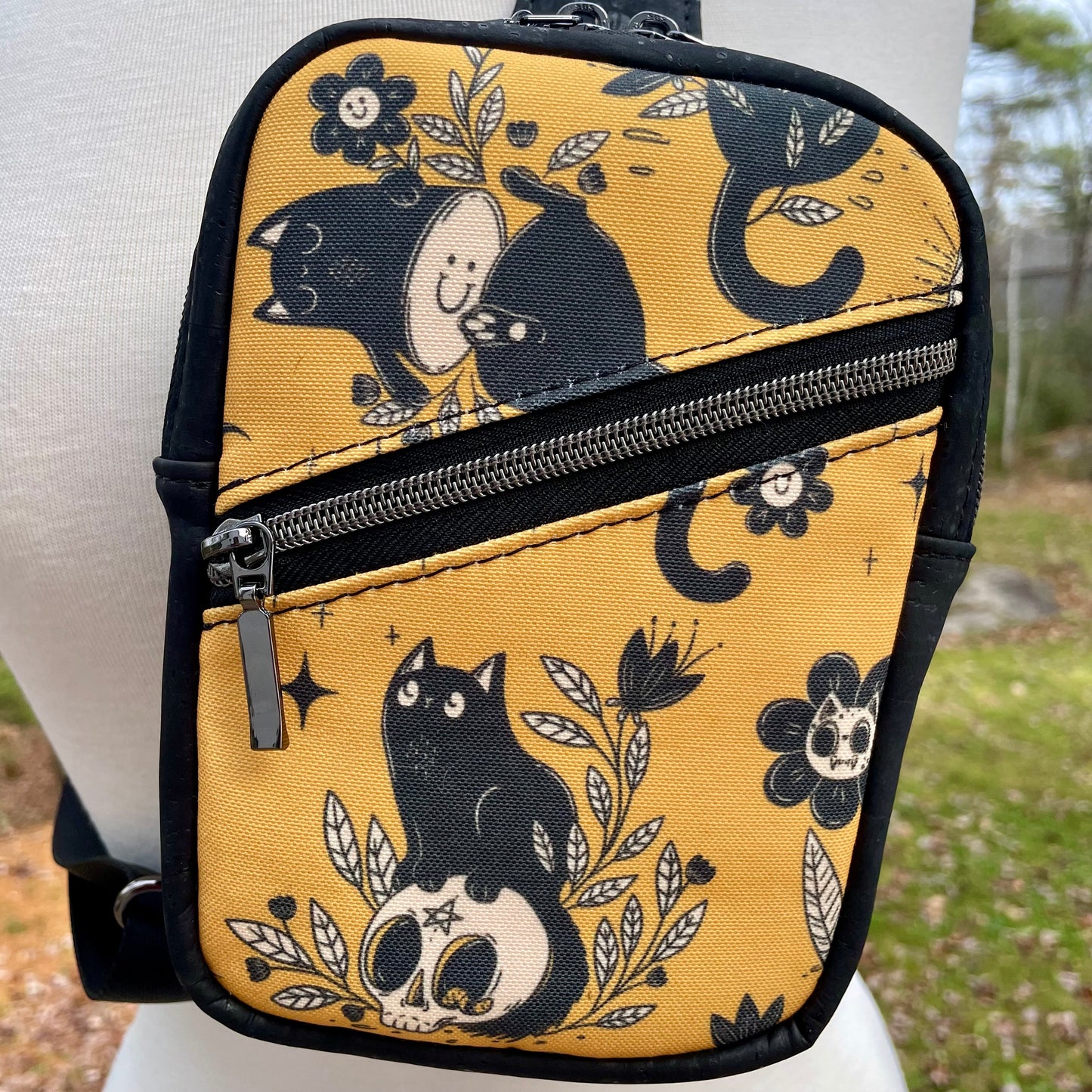 Sac de corps en liège noir à motifs de chats et de fleurs.