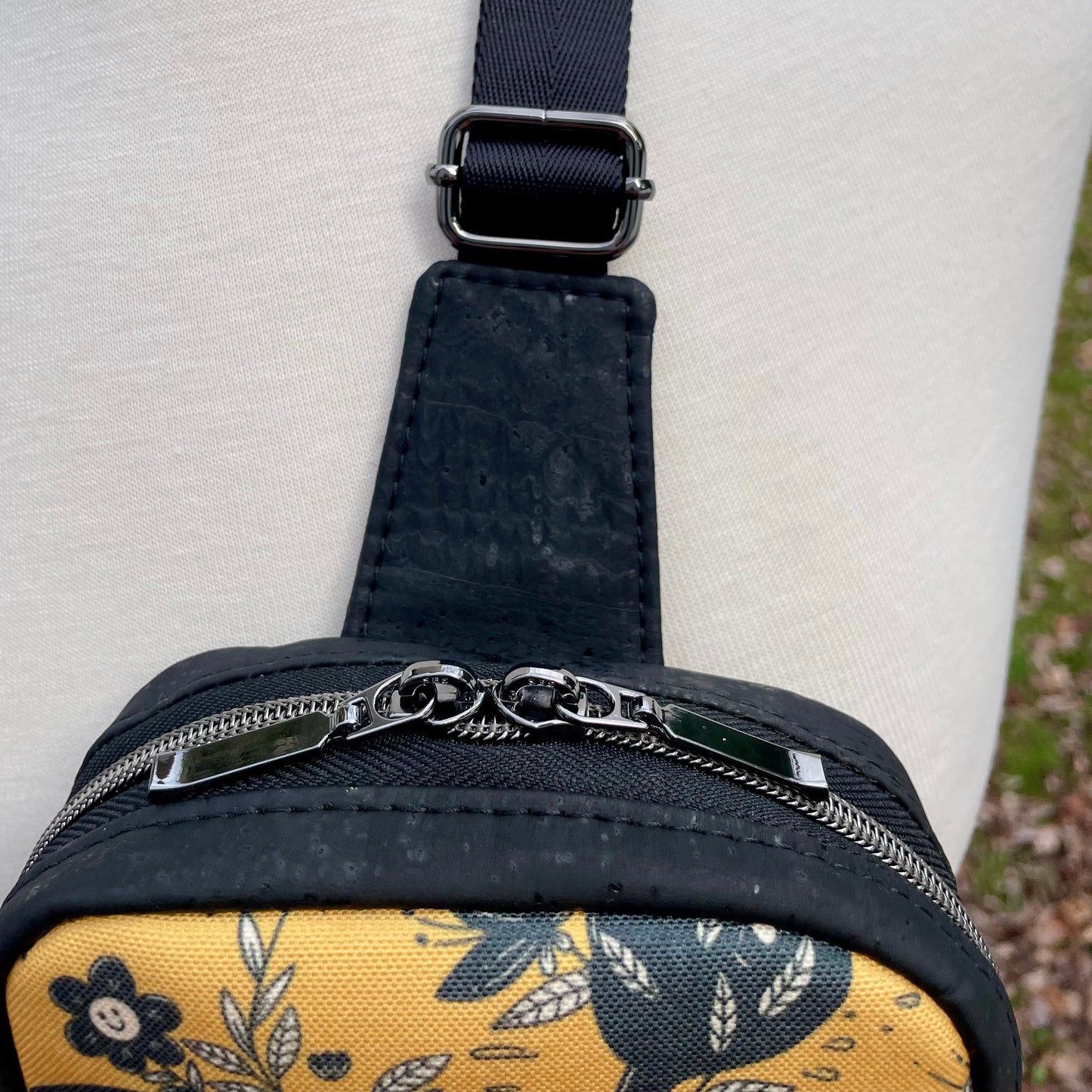 Sac de corps en liège noir à motifs de chats et de fleurs.