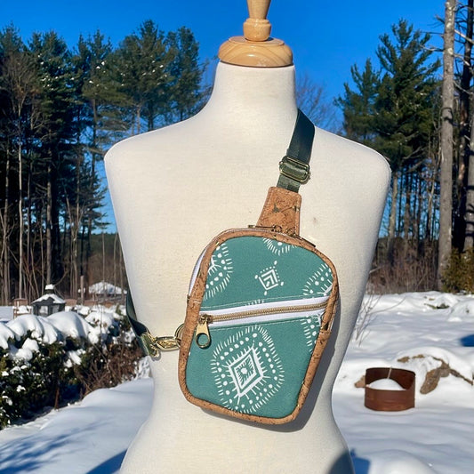 Sac de corps en liège noir au devant en canevas à motifs lignés verts et blancs.