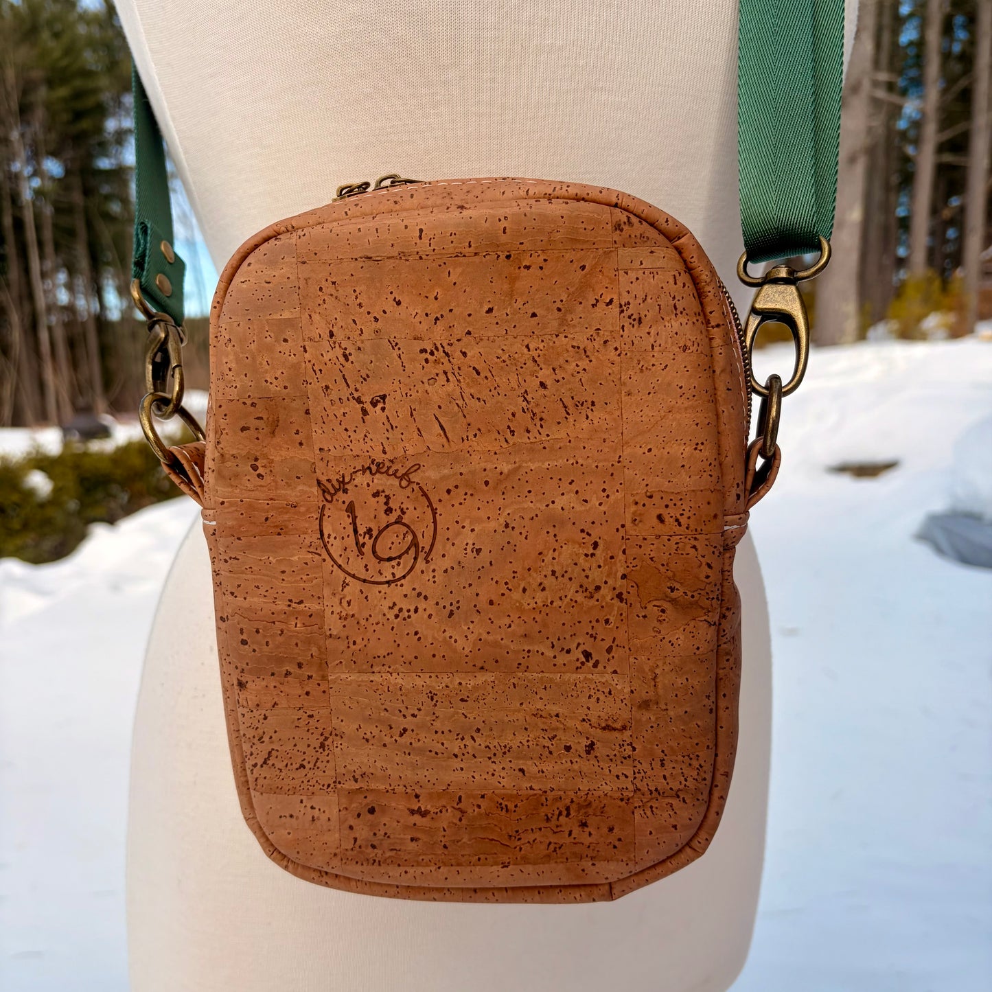 Sac bandoulière en liège brun pâle au devant en canevas à motif montagnes colorées.