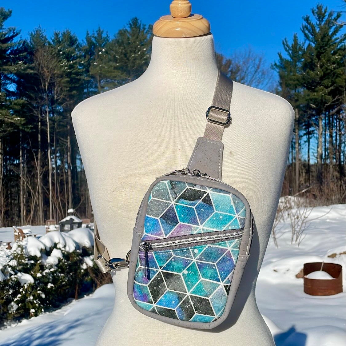 Sac de corps en liège noir au devant en canevas à motifs géométriques.