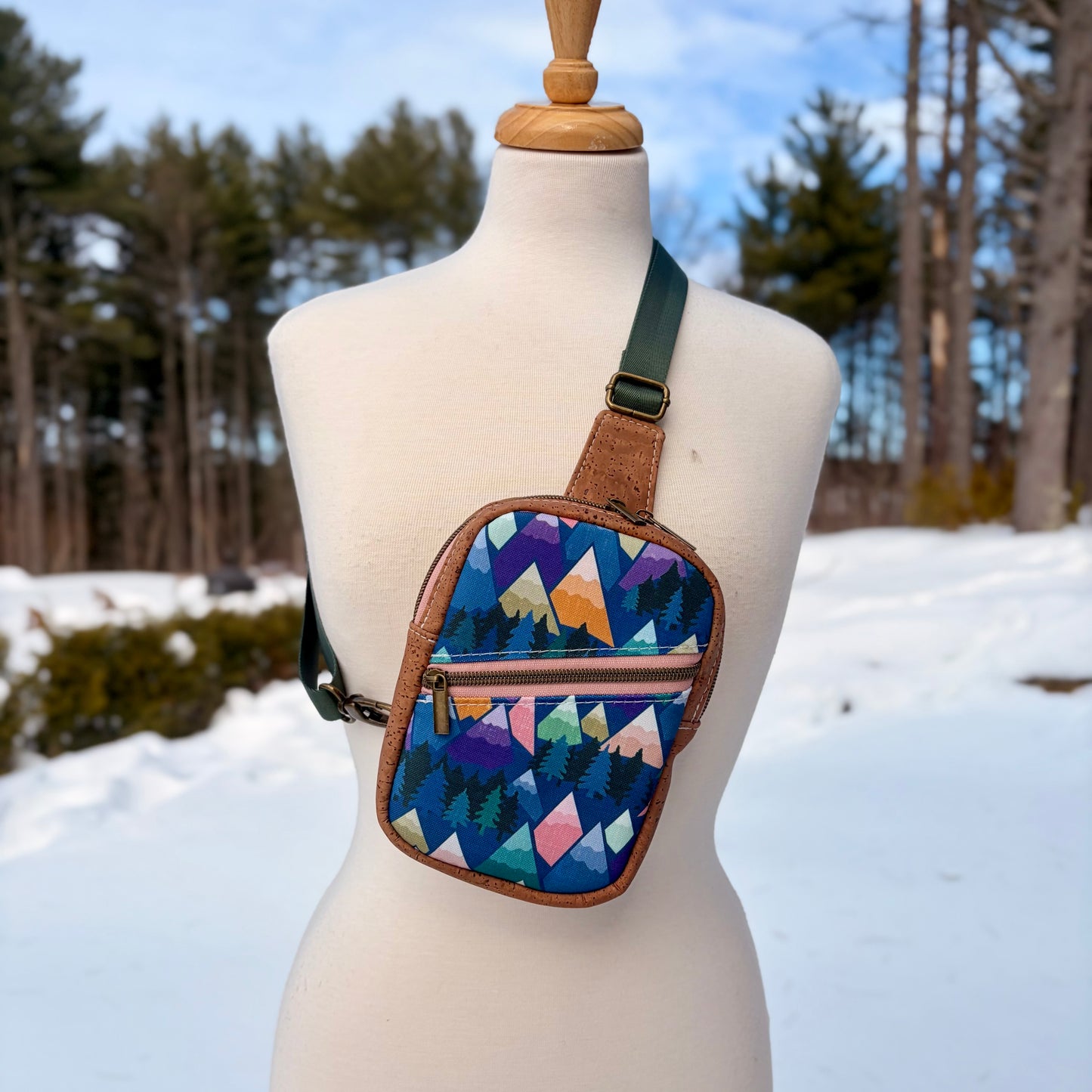 Sac de corps en liège brun pâle au devant en canevas à motif de montagnes colorées.