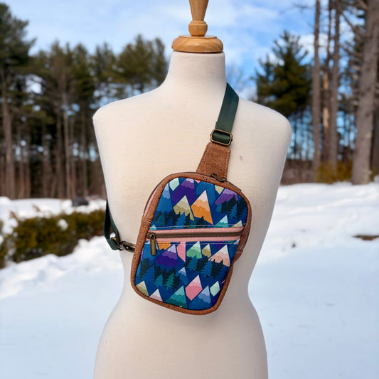 Sac de corps en liège brun pâle au devant en canevas à motif de montagnes colorées.