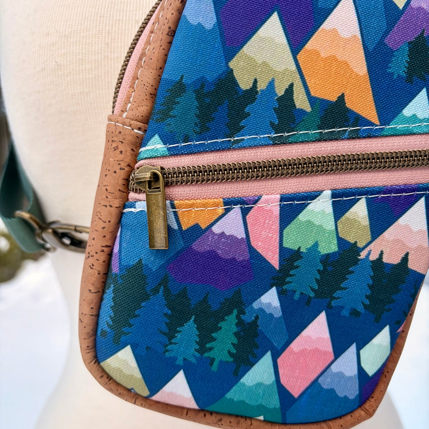 Sac de corps en liège brun pâle au devant en canevas à motif de montagnes colorées.