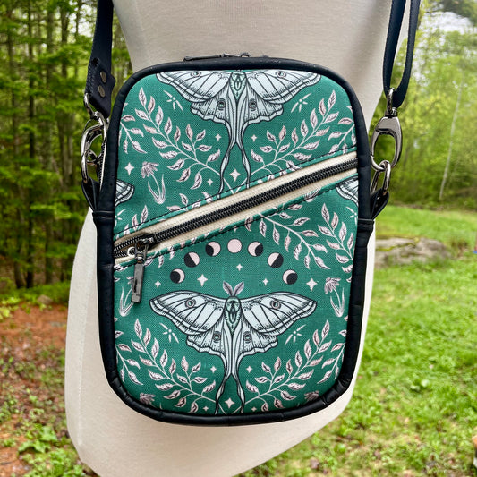 Sac bandoulière en liège noir au devant en canevas vert à motif de papillons noirs et beiges