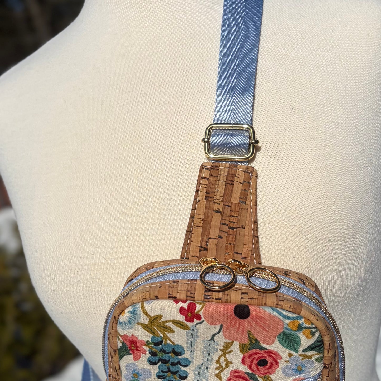 Sac de corps en liège naturel au devant en canevas à motif de fleurs colorées.