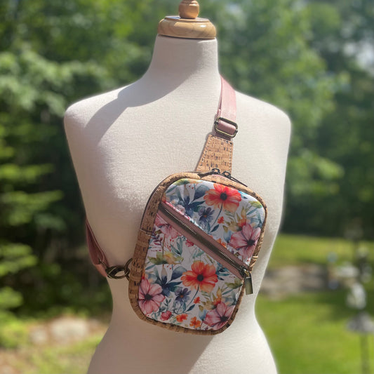 Sac de corps en liège brun pâle au devant en canevas à motifs de fleurs colorées.
